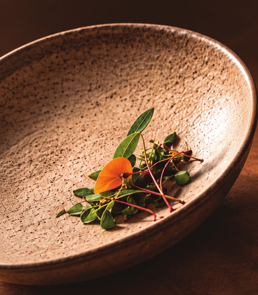 Delicate garnish of microgreens and a marigold petal in a stoneware bowl